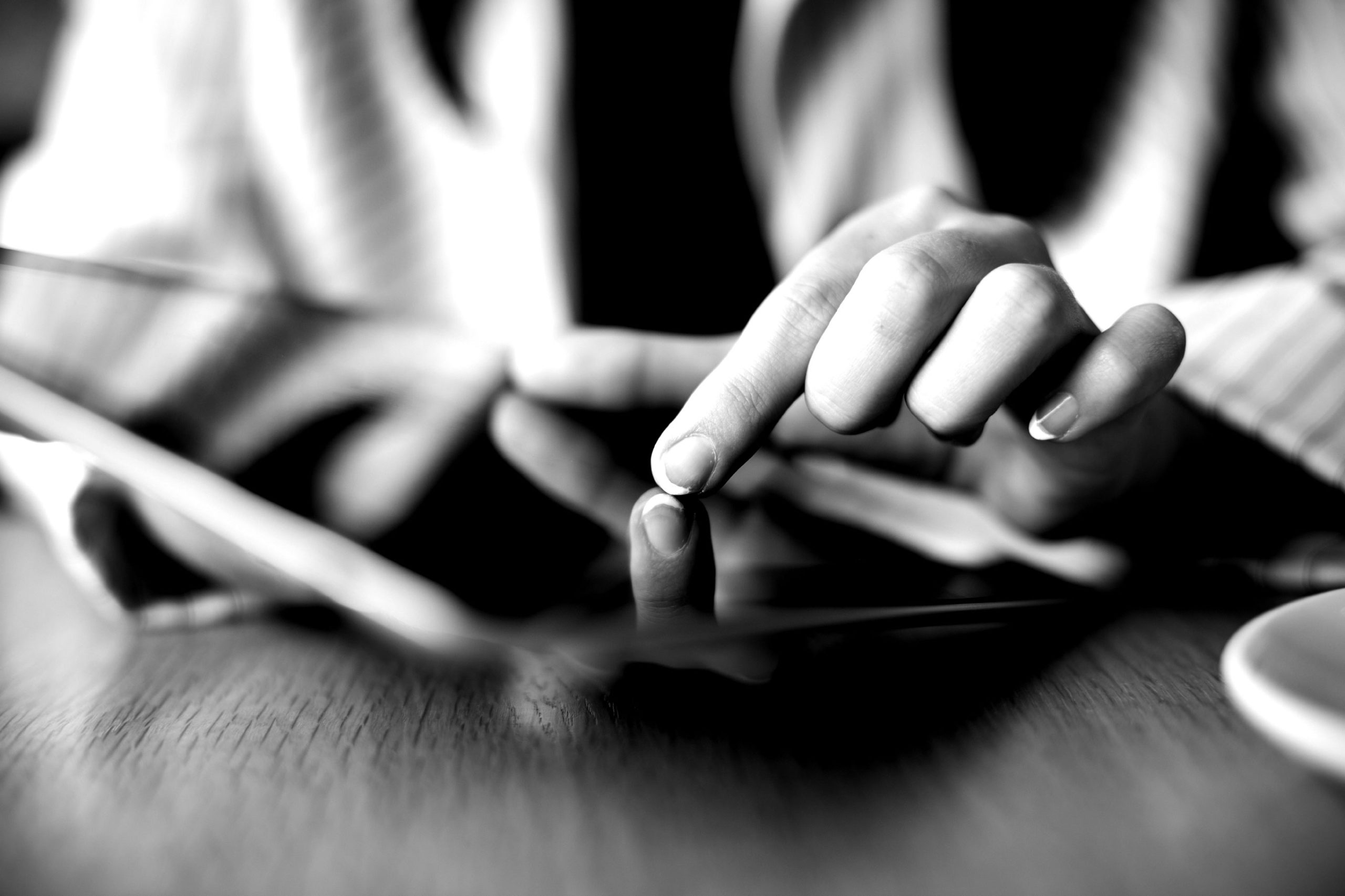 Close-up of hands using a tablet on a desk